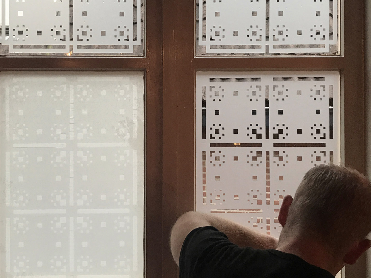 Het plakken van een raamfolie patroon in trappenhuis