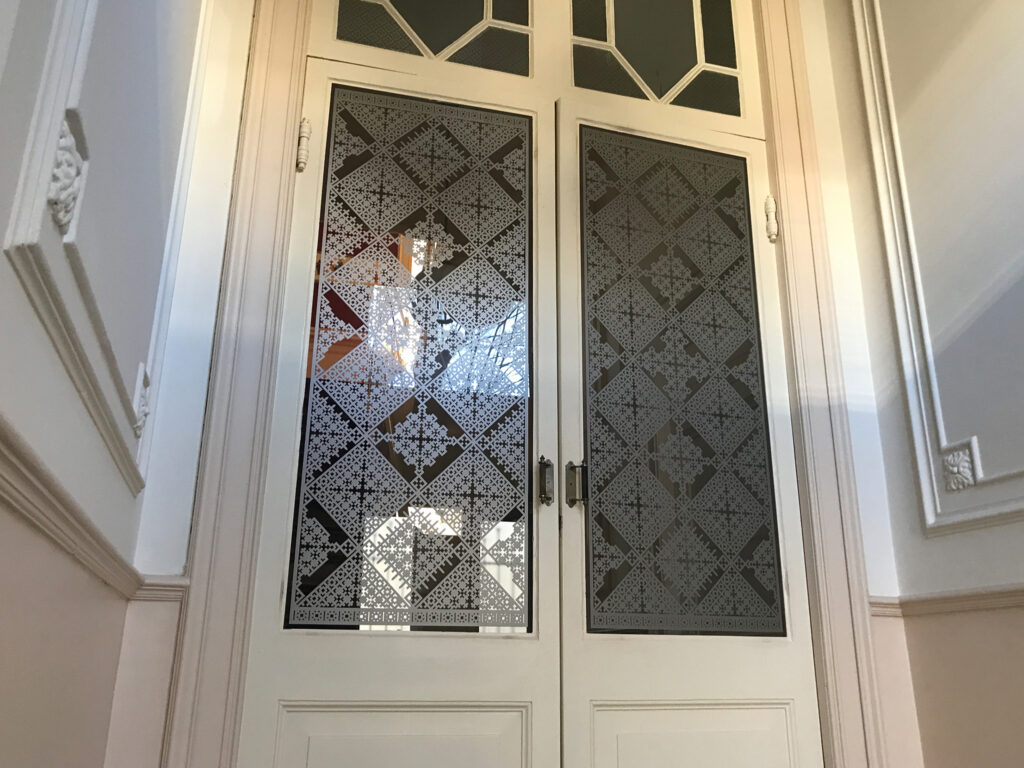 Raamfolie van een Schutspatroon op vestibule deuren voor privacy en visuele beschutting.
