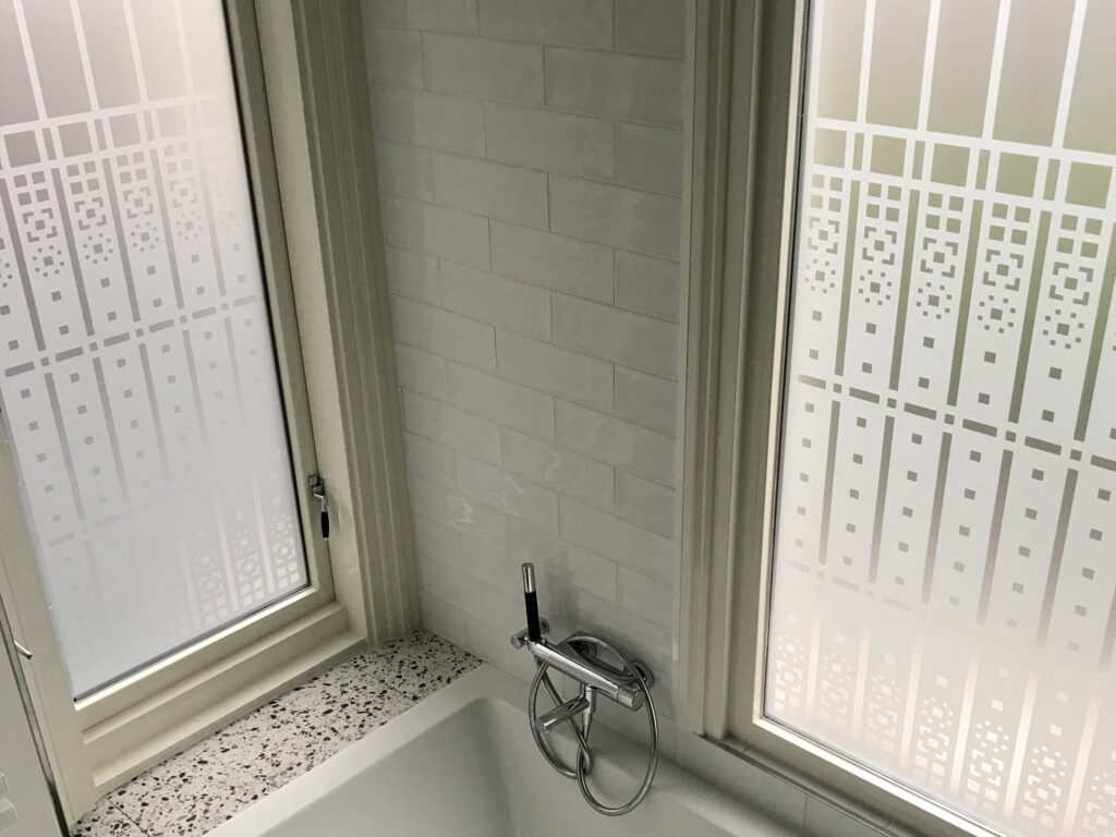 Raamfolie van een Schutspatroon in een badkamer voor privacy en visuele beschutting.