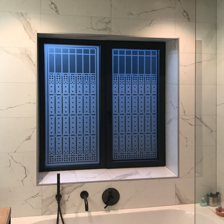 Raamfolie patroon voor badkamers in avondlicht.