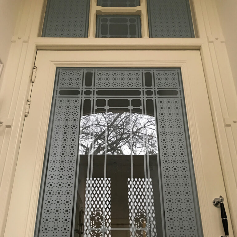 Schutspatroon op maat op tochtdeur in vestibule.