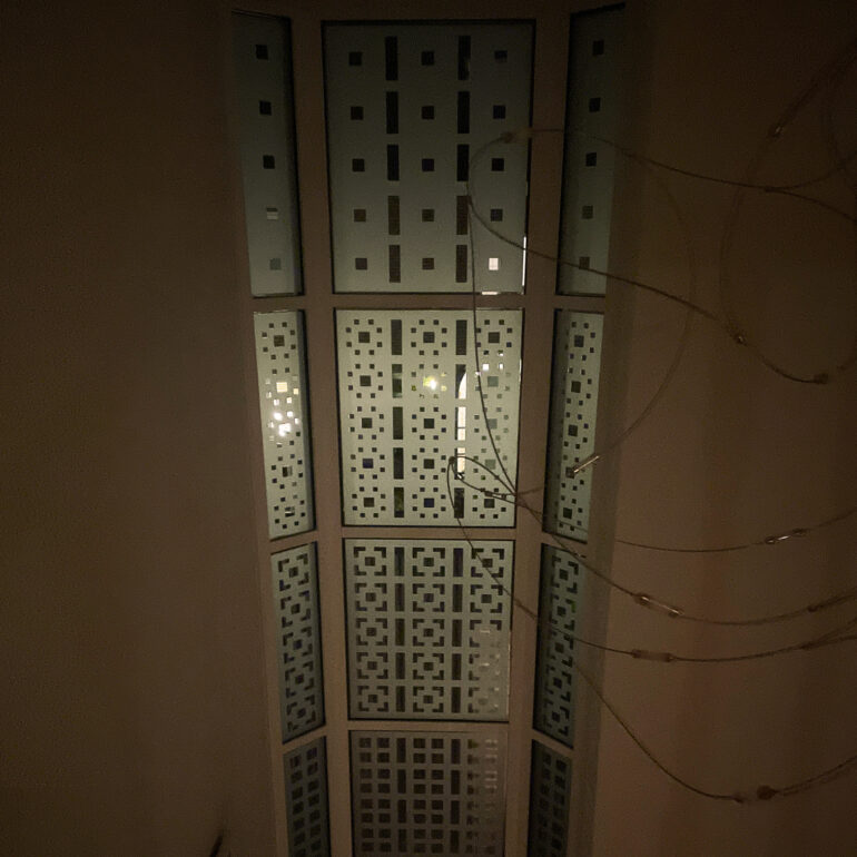 Schutspatroon in trappenhuis bij avond.
