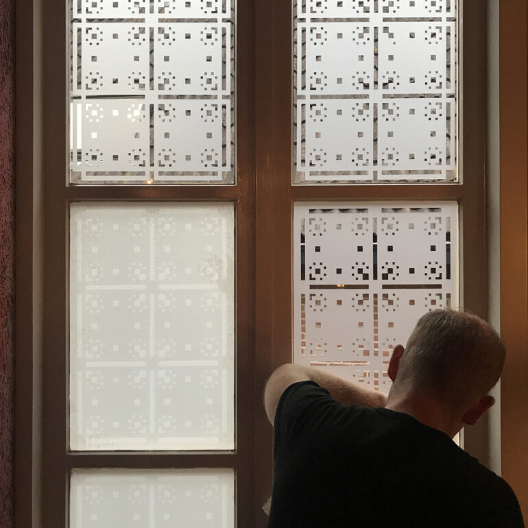 Het aanbrengen van een raamfolie patroon in een trappenhuis.